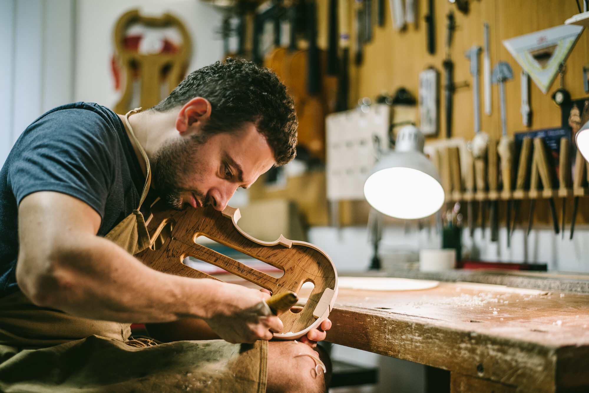 Erli Gurra carving a violin body in his workshop