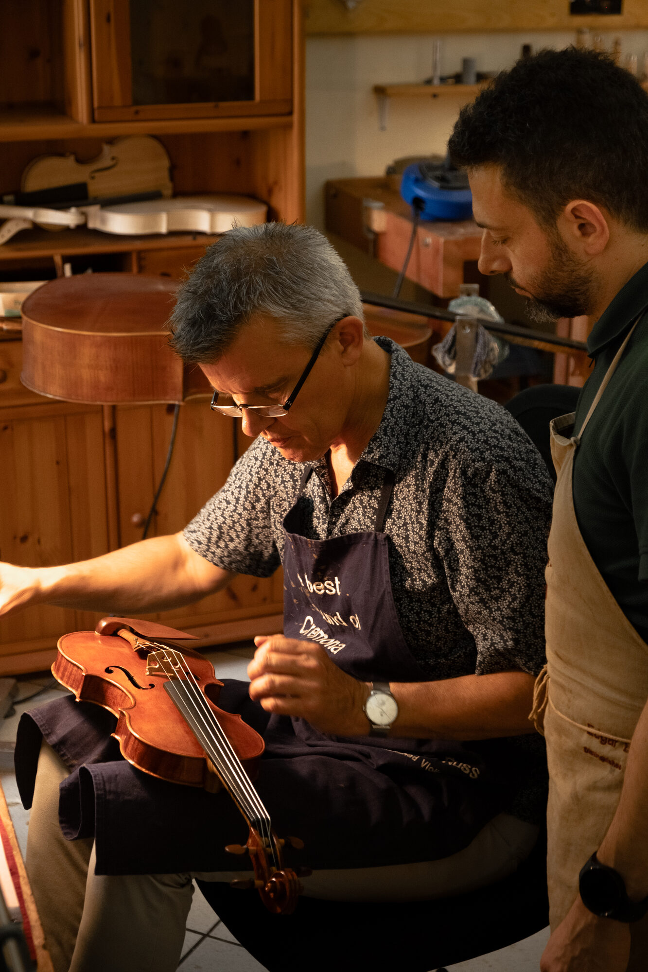 Erli Gurra and M° Edgar E. Russ examining a violin together