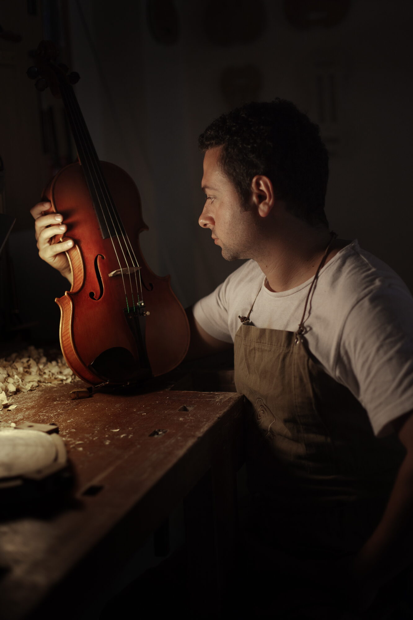 Erli Gurra examining a finished viola in his workshop